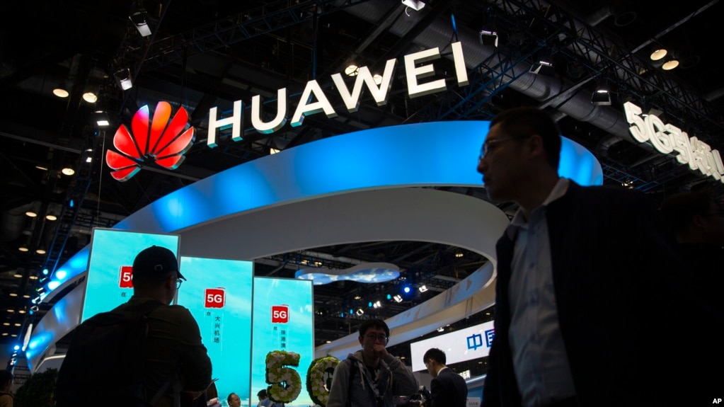 資料照片:在北京舉行的 PT 博覽會上,與會者走過中國技術公司華為的 5G 服務展示。(2019年10月31日)