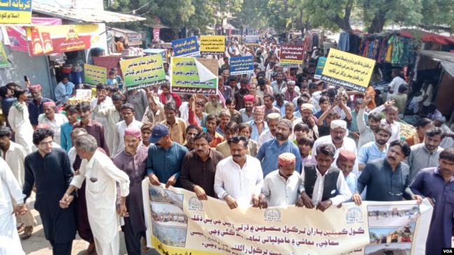 2024年10月20日,在巴基斯坦塔帕卡的伊斯拉姆科特,游行队伍经过这里的一个主要集市,高呼反对燃煤电厂和塔尔煤矿项目的口号。 2024年10月20日,在巴基斯坦塔帕卡的伊斯拉姆科特,游行队伍经过这里的一个主要集市,高呼反对燃煤电厂和塔尔煤矿项目的口号。