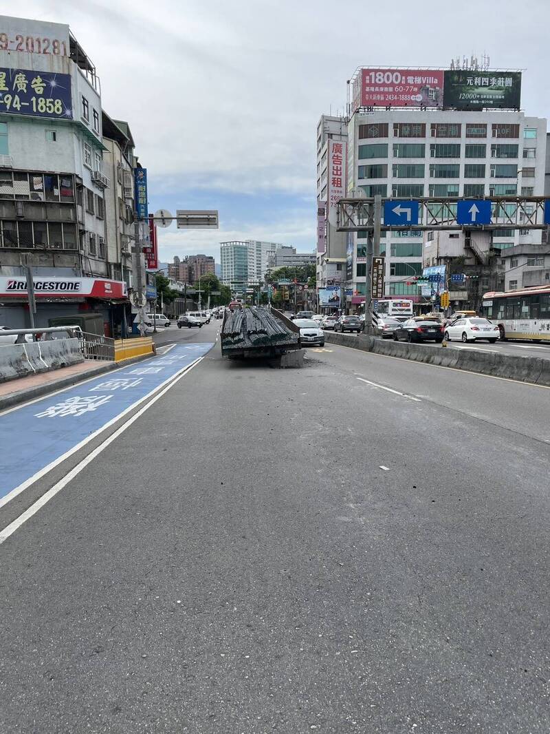 一辆载著钢板的大型拖车在行经秀朗桥往中和方向时，拖车与前方曳引车竟突然「首尾分离」，卡在桥上。（记者郑景议翻摄）