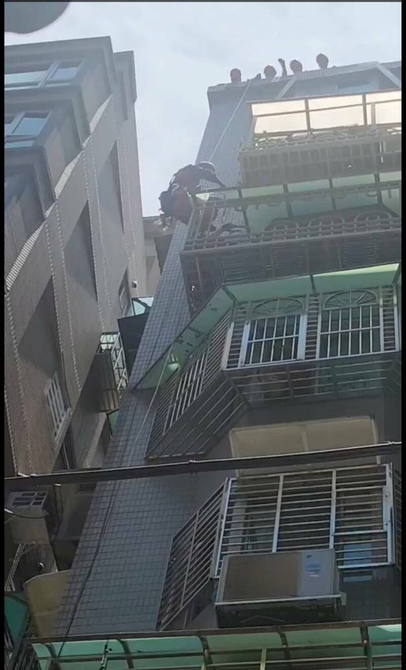 新北市淡水一名住户坠落六楼邻居阳台，消防一度尝试吊挂救人。（记者吴仁捷翻摄）