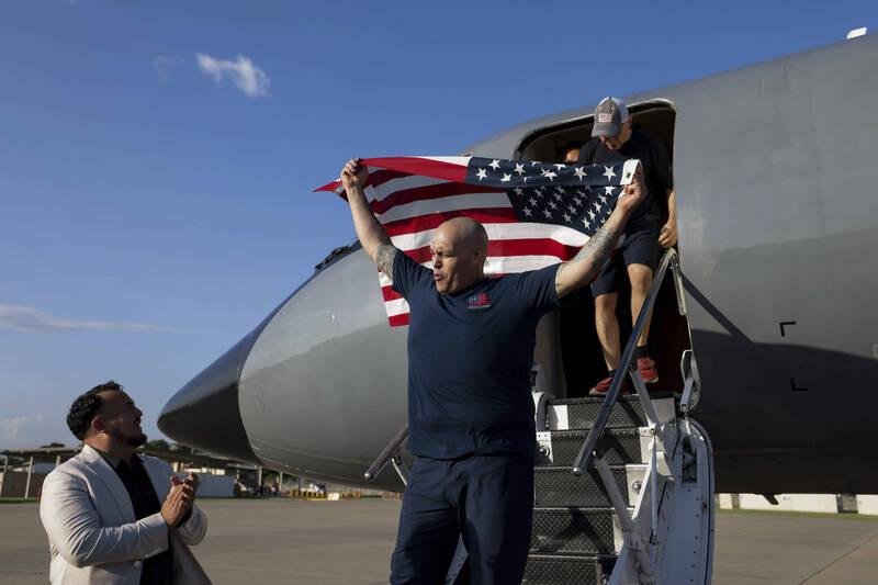 美国换回10名囚犯,获释其中一人到达机场后挥舞国旗。(美联) 美国换回10名囚犯,获释其中一人到达机场后挥舞国旗。(美联)