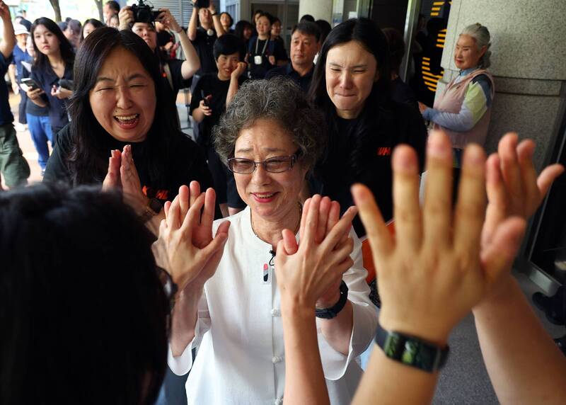 61年前因咬斷性侵未遂者舌頭而遭定罪的崔末子（中），23日在釜山地方法院出席重審聽證會後，被支持者的掌聲所包圍。（法新社）